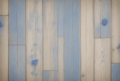 The primary subject of the image is a wooden floor with a blue tint. The setting is a room with a wooden floor, and the visual style is a photo. The dominant colors are blue and white, creating a calm and serene atmosphere.