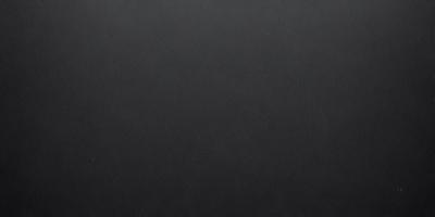 The primary subject of the image is a black background. The setting is a dark room, and the visual style is a black and white photo. The colors and mood of the image are dark and moody, creating a sense of mystery or drama.