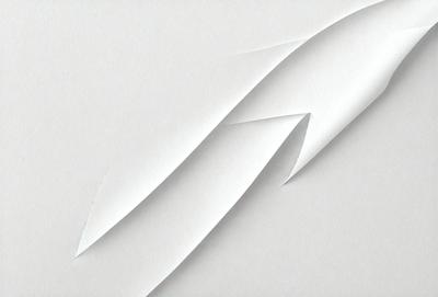 The primary subject of the image is a white paper with a creased, folded, or crumpled appearance. The paper is the main object, scene, or focus of the image. The setting or background is a white surface, which provides a clean and uncluttered backdrop for the paper. The visual style of the image is a close-up of the paper, showcasing its texture and creases. The colors and mood of the image are predominantly white, giving it a clean and minimalist appearance