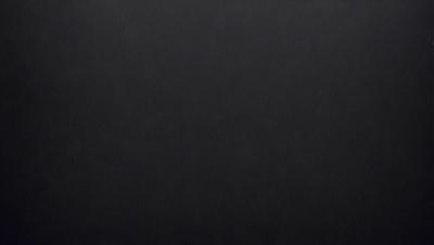 The primary subject of the image is a black background. The setting is a dark room, and the visual style is a black and white photo. The colors and mood of the image are predominantly dark and moody.