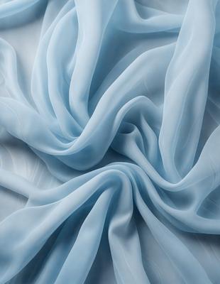 The primary subject of the image is a blue sheet of fabric, which is the main object, scene, or focus of the image. The setting or background is a white surface, and the visual style is a photo. The colors and mood of the image are predominantly blue, creating a calm and serene atmosphere.
