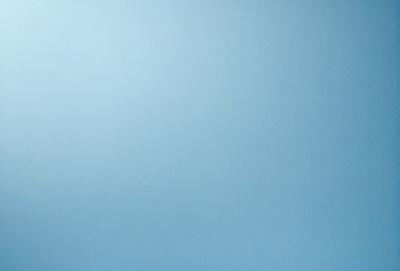 The primary subject of the image is a large, empty blue sky. The setting is a vast, open space with no visible landmarks or objects. The visual style is a natural, outdoor scene with a focus on the sky. The colors and mood are predominantly blue, creating a calm and serene atmosphere.