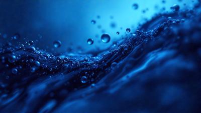 The primary subject of the image is a blue ocean with a few bubbles floating on the surface. The setting is the ocean, and the visual style is a photo. The dominant colors are blue and white, creating a calm and serene atmosphere.