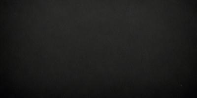 The primary subject of the image is a black background. The setting is a dark room, and the visual style is a black and white photo. The colors and mood of the image are dark and moody, creating a sense of mystery or drama.