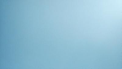 The primary subject of the image is a large, empty blue sky. The setting is a vast, open space with no visible landmarks or objects. The visual style is a natural, untouched landscape. The colors and mood are predominantly blue, creating a calm and serene atmosphere.