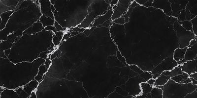 The image is a black and white photo of a marble wall. The marble wall has a textured and rough appearance, giving it a natural and elegant look. The primary subject of the image is the marble wall, which serves as the main focus of the scene. The setting is a black and white photo, which adds a timeless and classic feel to the image. The visual style is a close-up of the marble wall, allowing the viewer to appreciate the intricate details of the stone. The colors and mood
