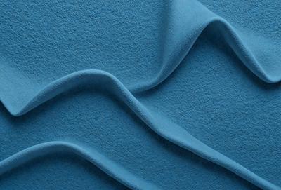 The primary subject of the image is a blue surface, which appears to be a piece of fabric or a wall with a blue color. The setting is a room with a blue carpet, and the visual style is a close-up of the blue surface. The colors and mood of the image are predominantly blue, creating a calm and serene atmosphere.