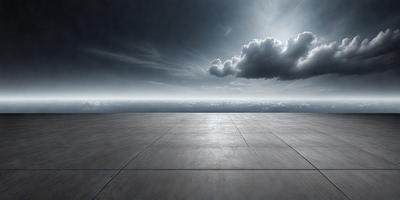 The primary subject of the image is a large, empty concrete platform. The platform is situated in front of a cloudy sky, which serves as the setting and background of the scene. The visual style of the image is a black and white photo, giving it a classic and timeless appearance. The colors and mood of the image are predominantly dark and moody, with the cloudy sky and empty platform creating a sense of solitude and emptiness.