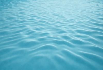 The primary subject of the image is a large body of blue water, which appears to be a lake. The water is calm and serene, with no visible disturbances or ripples. The setting is a natural environment, with the water being the main focus of the scene. The visual style of the image is a realistic representation of the water, without any digital manipulation or artistic elements. The colors and mood of the image are predominantly blue, creating a sense of tranquility and peacefulness.