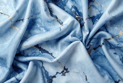 The primary subject of the image is a blue fabric with a gold pattern. The setting is a blue background, and the visual style appears to be a photo. The dominant colors are blue and gold, creating a calm and elegant atmosphere.