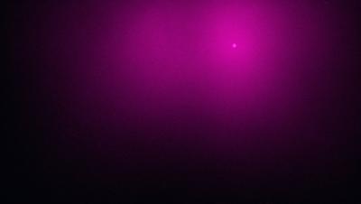 The primary subject of the image is a purple background. The setting is a dark, purple room with a pinkish glow. The visual style is a digital art or illustration, creating a unique and artistic atmosphere. The dominant colors are purple and pink, giving the scene a moody and mysterious vibe.