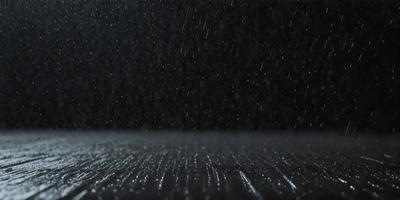 The primary subject of the image is a rainy night scene with a dark background. The setting is a wet street, and the visual style is a black and white photo. The colors and mood of the image are predominantly dark and moody, with the rain creating a sense of atmosphere and depth.