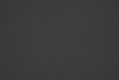 The primary subject of the image is a dark grey surface, which appears to be a textured wall or a dark grey carpet. The setting is indoors, with the surface being the main focus of the image. The visual style is a close-up of the surface, showcasing its texture and color. The colors and mood of the image are dark and moody, with the grey surface being the dominant color.
