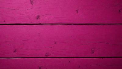 The primary subject of the image is a pink wooden wall. The setting is a room with a pink wall, and the visual style is a close-up of the wall. The dominant colors are pink, and the overall atmosphere is warm and inviting.