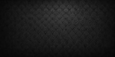 The primary subject of the image is a black and white patterned wallpaper. The setting is a black background, which contrasts with the patterned wallpaper. The visual style is a close-up of the wallpaper, showcasing its intricate design. The colors and mood of the image are predominantly black and white, giving it a classic and elegant appearance.