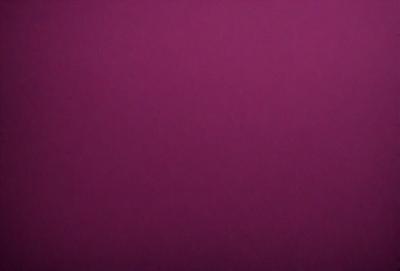 The primary subject of the image is a large, purple wall. The setting is a room with a pink background, which creates a contrasting and vibrant atmosphere. The visual style is a close-up of the wall, showcasing its color and texture. The dominant colors are purple and pink, giving the scene a warm and inviting mood.