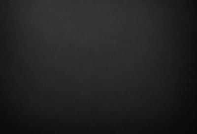 The primary subject of the image is a black background. The setting is a dark room, and the visual style is a black and white photo. The colors and mood are dark and moody, creating a sense of mystery or drama.