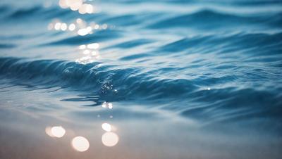 The primary subject of the image is a body of water, which appears to be a large lake or ocean. The water is blue and has a few ripples, creating a serene and peaceful atmosphere. The setting is outdoors, with the water being the main focus of the scene. The visual style of the image is a photo, capturing the natural beauty of the water. The colors and mood of the image are predominantly blue, with a hint of white from the ripples, creating a calming and