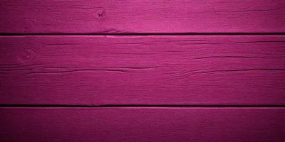 The primary subject of the image is a pink wooden wall. The setting is a room with a wooden surface, and the visual style is a close-up of the wall. The dominant colors are pink and purple, creating a warm and inviting atmosphere.