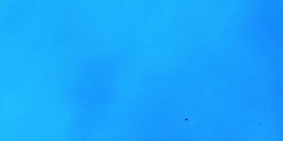 The primary subject of the image is a jet flying through the sky. The setting is a clear blue sky, with no clouds or other obstructions visible. The visual style is a photo, capturing the jet in motion against the backdrop of the blue sky. The colors and mood of the image are predominantly blue, creating a sense of calm and tranquility.