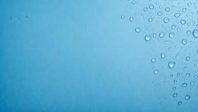 The primary subject of the image is a blue wall with water droplets on it. The setting is a room with a blue background. The visual style is a close-up of the blue wall with water droplets. The colors and mood of the image are predominantly blue, creating a calm and serene atmosphere.