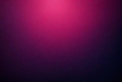 The primary subject of the image is a pink background. The setting is a dark, purple-colored room. The visual style is a close-up of the pink background, which creates a vibrant and bold atmosphere. The colors and mood of the image are predominantly pink and purple, giving it a warm and inviting feel.