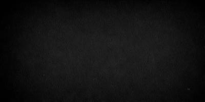 The primary subject of the image is a black background. The setting is a dark room, and the visual style is a black and white photo. The colors and mood of the image are dark and moody, creating a sense of mystery or drama.