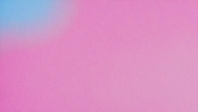 The primary subject of the image is a pink background. The setting is a blank wall, and the visual style is a close-up of the pink background. The colors and mood of the image are predominantly pink, creating a warm and inviting atmosphere.