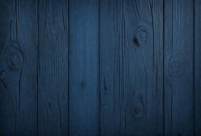 The primary subject of the image is a wooden wall with a blue color. The setting is a room with a wooden surface, and the visual style is a close-up of the wooden wall. The dominant colors are blue and brown, creating a calm and natural atmosphere.