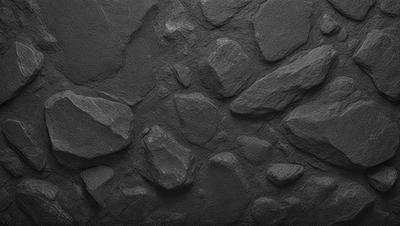 The primary subject of the image is a large rock wall with a variety of rocks and boulders. The setting is a rocky surface, and the visual style is a black and white photo. The dominant colors are black and white, and the overall atmosphere is rugged and natural.