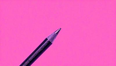 The primary subject of the image is a pencil, which is prominently displayed in the foreground. The setting is a pink background, which creates a contrasting and visually striking scene. The visual style of the image is a close-up of the pencil, emphasizing its details and texture. The colors and mood of the image are predominantly pink, giving it a warm and vibrant atmosphere.