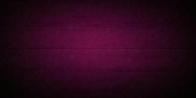 The primary subject of the image is a purple wall. The setting is a dark room with a purple wall, which creates a moody atmosphere. The visual style is a close-up of the purple wall, showcasing its texture and color. The dominant colors are purple and black, giving the image a dramatic and intense feel.