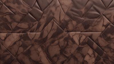The primary subject of the image is a brown leather material, which appears to be a piece of leather furniture. The setting is a room with a brown leather wall, which adds to the overall atmosphere. The visual style of the image is a close-up of the leather material, showcasing its texture and details. The colors in the image are predominantly brown, giving the scene a warm and cozy ambiance.
