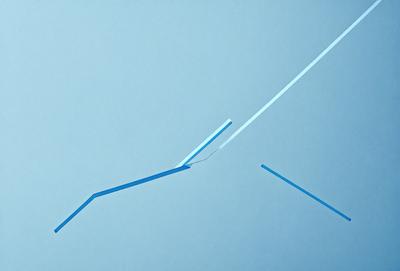 The primary subject of the image is a blue background with a white line on it. The setting appears to be a blue wall or a blue surface. The visual style of the image is a combination of a photo and a drawing, creating a unique and artistic representation. The colors and mood of the image are predominantly blue, with a touch of white, giving it a calm and serene atmosphere.