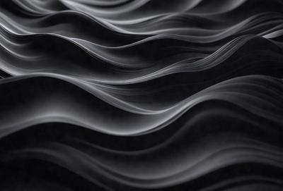 The primary subject of the image is a black and white photo of a wave. The setting is a dark background, and the visual style is a close-up of the wave. The dominant colors are black and white, creating a moody atmosphere.