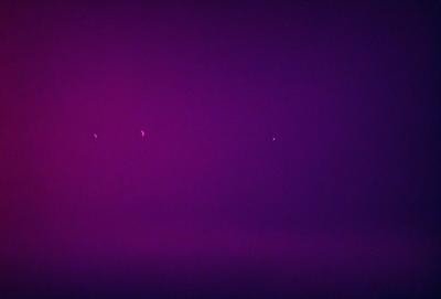 The image is a purple background with two small, bright stars in the foreground. The purple background creates a contrasting and visually striking scene. The two stars are the primary subject, and their position in the foreground adds depth and interest to the image. The overall atmosphere is calm and serene, with the purple hue evoking a sense of tranquility.