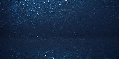The primary subject of the image is a blue background with a pattern of glittering stars. The setting is a dark room, and the visual style appears to be a digital art or illustration. The dominant colors are blue and white, creating a calm and serene atmosphere.