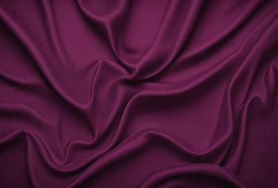 The primary subject of the image is a purple fabric, which is the main object, scene, or focus of the image. The setting or background is a purple curtain, and the visual style is a close-up of the fabric. The colors and mood of the image are predominantly purple, creating a calm and soothing atmosphere.