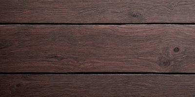 The primary subject of the image is a wooden floor. The setting is a room with a wooden floor, and the visual style is a photo. The colors and mood of the image are predominantly brown, giving it a warm and natural atmosphere.