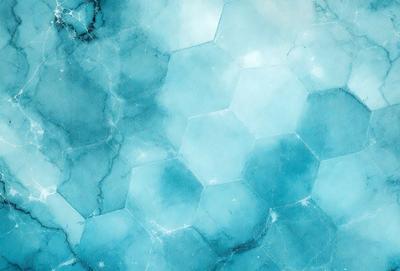 The primary subject of the image is a blue and white marble pattern. The setting is a blue and white marble surface, which serves as the background. The visual style is a close-up of the marble pattern, showcasing its intricate details. The colors and mood of the image are predominantly blue and white, creating a serene and elegant atmosphere.