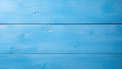 The primary subject of the image is a blue wooden wall. The setting is a room with a blue wooden wall, and the visual style is a photo. The dominant colors are blue and white, creating a calm and serene atmosphere.