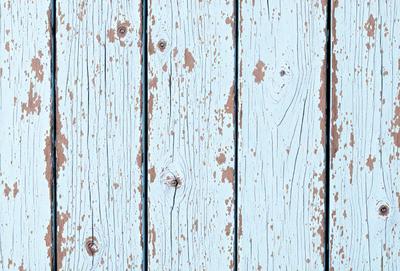 The primary subject of the image is a wooden plank with a blue background. The setting is a wooden surface, possibly a wall or a table. The visual style is a close-up of the wooden plank, showcasing its texture and details. The colors and mood of the image are predominantly blue, giving it a calm and serene atmosphere.