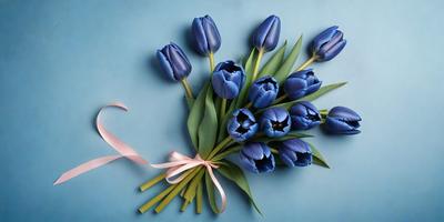 The primary subject of the image is a bouquet of blue flowers, which are the main focus of the scene. The flowers are arranged in a vase, and they are placed on a blue surface, which adds a sense of depth and color to the image. The visual style of the image is a close-up of the flowers, showcasing their beauty and details. The colors and mood of the image are predominantly blue, creating a calm and serene atmosphere.