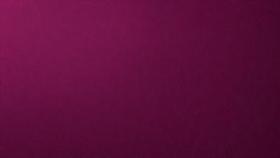 The primary subject of the image is a large, purple surface. The setting is a dark room, and the visual style is a close-up of the purple surface. The colors and mood of the image are predominantly purple, creating a calm and serene atmosphere.