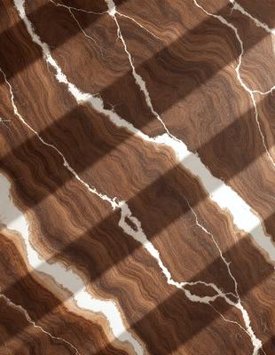 The primary subject of the image is a marble countertop with a brown and white pattern. The setting is a kitchen, and the visual style is a photo. The countertop has a natural and earthy color palette, giving it a warm and inviting atmosphere.