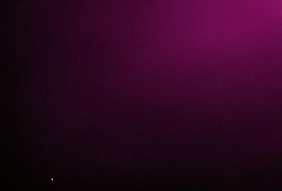 The image is a purple background with a dark, foggy atmosphere. The primary subject is a bright star, which stands out against the dark and foggy background. The visual style appears to be a photo, and the colors and mood convey a sense of mystery and depth.