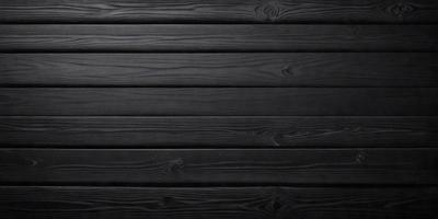 The primary subject of the image is a wooden wall. The setting is a black background, which creates a striking contrast with the wooden surface. The visual style is a close-up of the wooden wall, showcasing its texture and details. The colors and mood of the image are predominantly black, giving it a dramatic and moody atmosphere.