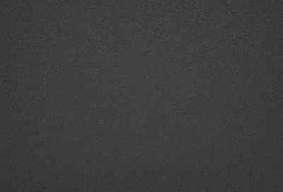 The primary subject of the image is a black surface, which appears to be a wall or a piece of fabric. The setting is a dark room, and the visual style is a close-up of the black surface. The colors and mood of the image are predominantly dark and moody, with the black surface being the main focus.