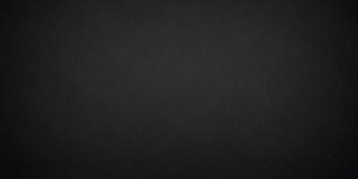 The primary subject of the image is a black background. The setting is a dark room, and the visual style is a black and white photo. The colors and mood of the image are predominantly dark and moody, with a sense of mystery and depth.