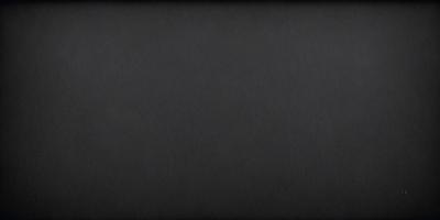 The primary subject of the image is a black background. The setting is a dark room, and the visual style is a black and white photo. The colors and mood of the image are dark and moody, creating a sense of mystery or drama.